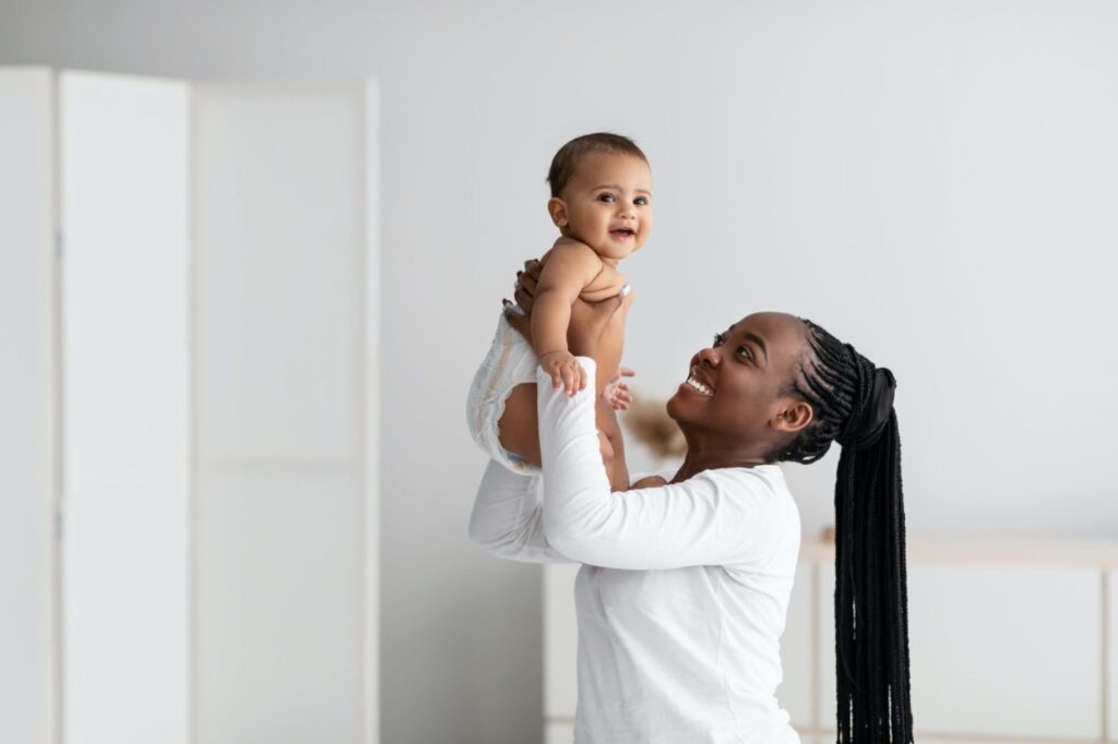 black-woman-playing-with-her-cute-little-baby-at-home-e1634117912841.jpg